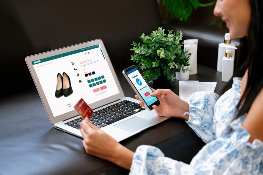 Woman shopping online on a Shopify store using laptop and mobile phone with secure payment