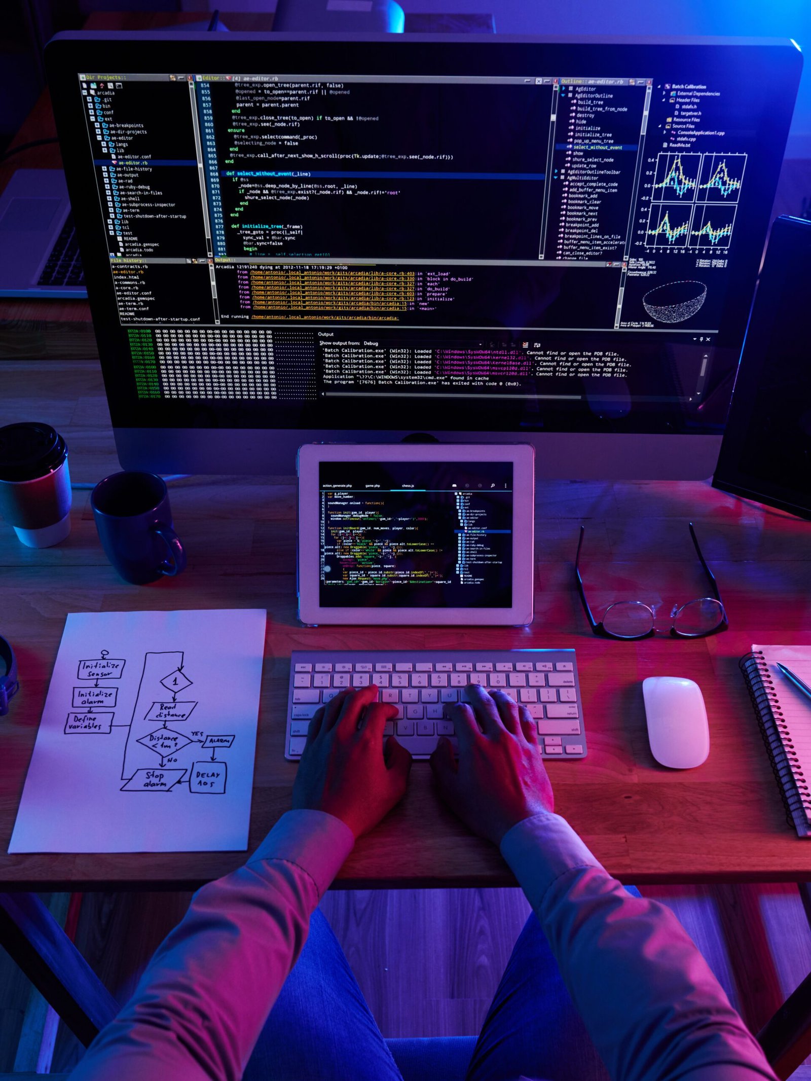 WordPress developer working on custom website code with multi-screen setup and flowchart for business site optimization